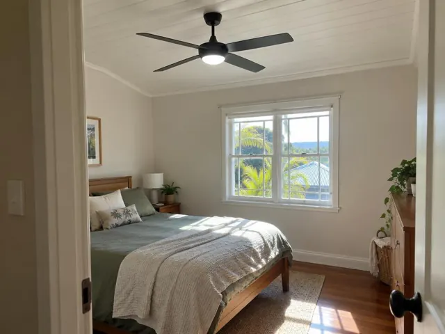 Ceiling fan fitted in a bright bedroom with white paneled ceiling and timber furniture in Mudgeeraba