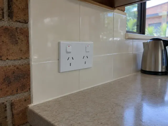 White double power point on tiled kitchen splashback beside a bench and window in Varsity Lakes